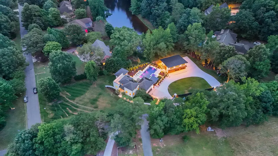 Wide aerial at dusk of the wooded 1.58-acre lot on a quiet cul-de-sac