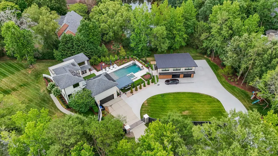 Daytime aerial of the house, pool, accessory building and lawn