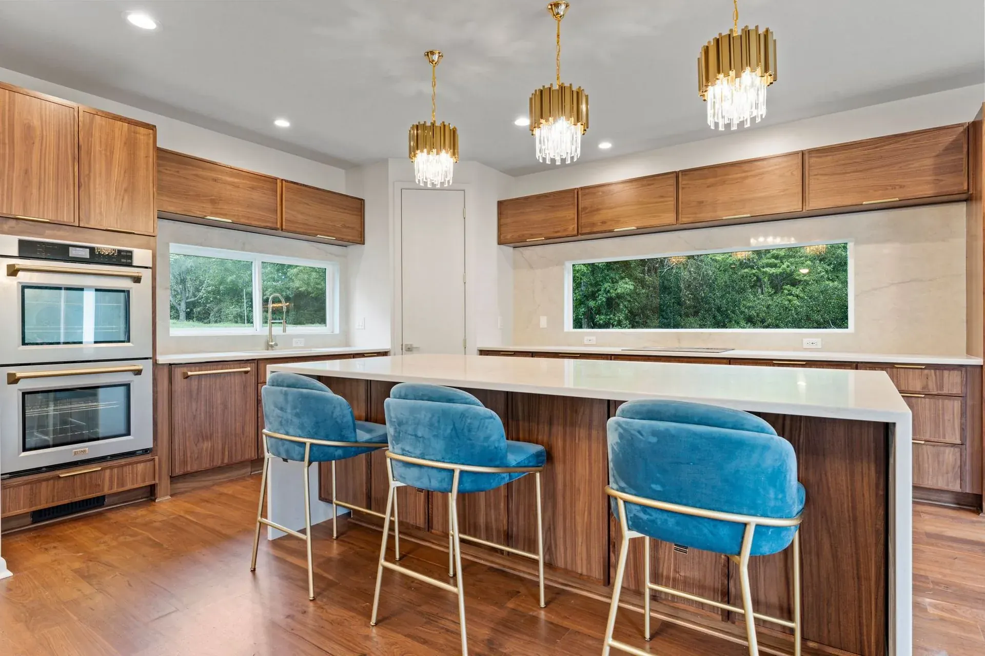 Designer kitchen with custom walnut cabinetry and waterfall quartz island
